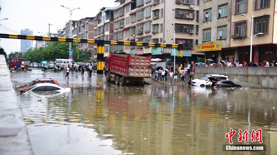 6月13日早上6时许，广西柳州市下起倾盆大雨，致使该市柳江区拉堡镇乐都大道涵洞积水约2米，多辆停放在此的车辆被水泡。该涵洞还未启用，附近不少居民将此处当停车场，而入口处被绿色的铁丝网围住，悬挂着“施工重地，闲人免进”，“施工通道，禁止停车”等字样的警示牌。 王以照 摄