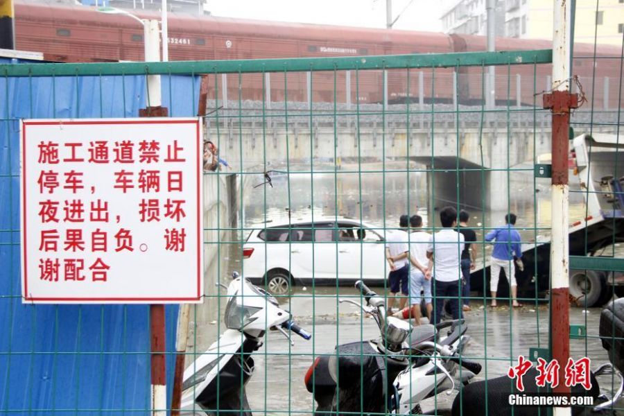 6月13日早上6时许，广西柳州市下起倾盆大雨，致使该市柳江区拉堡镇乐都大道涵洞积水约2米，多辆停放在此的车辆被水泡。该涵洞还未启用，附近不少居民将此处当停车场，而入口处被绿色的铁丝网围住，悬挂着“施工重地，闲人免进”，“施工通道，禁止停车”等字样的警示牌。 朱柳融 摄