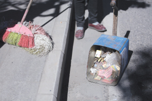 环卫工人清扫车主丢弃的广告卡片