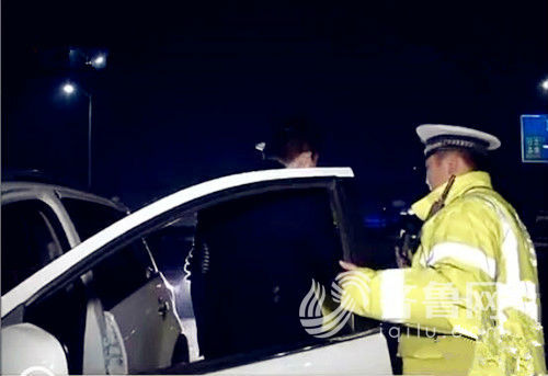 白色轿车司机下车接受交警夜查